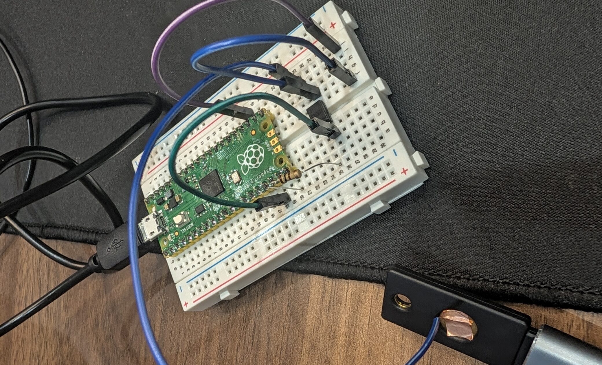 Breadboard prototype: a Raspberry Pi Pico with jumper wires running to a YubiKey with copper tape on its touch sensor
