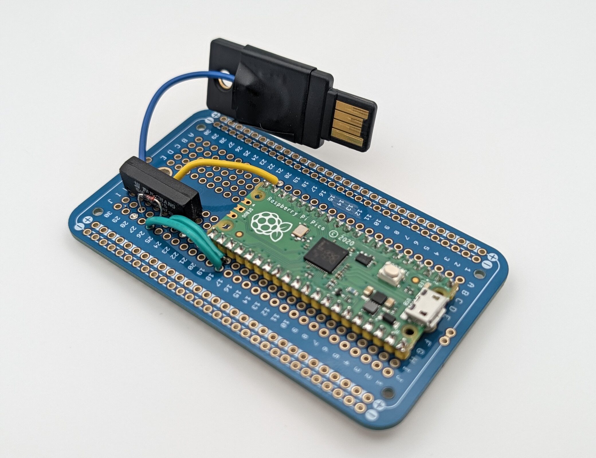 Soldered version: the Pico and reed relay on a blue protoboard, wired to the YubiKey’s touch sensor